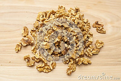 Pile of walnut pieces scattered on a wooden table Stock Photo