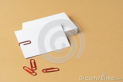 Pile of white businesscards with a clip on beige background Stock Photo