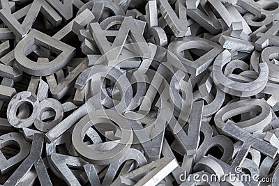 Pile of white metal alphabet characters cutted by waterjet machine Stock Photo