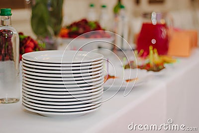 Pile of white plates on catering buffet. Stock Photo