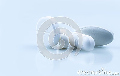 Pile of white round and oblong shape tablet pills on white background. Pharmaceutical industry. Pharmacy or drugstore Stock Photo