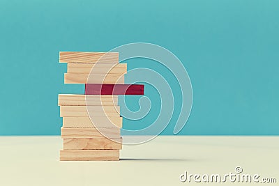 Pile of wooden blocks with one red plank. Uniqueness and originality. Think outside box. Not like everyone. Copy space Stock Photo