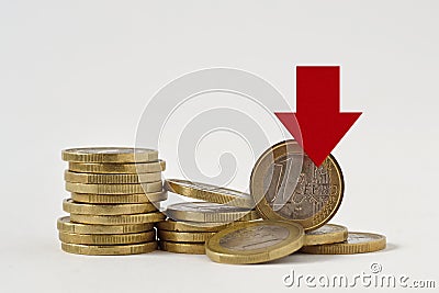 Piles of euro coins with red decreasing arrow on white background - Concept of decrease in euro value and loss of money Stock Photo