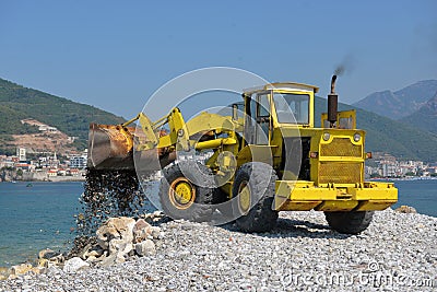 Piles of shingle dumped on the beach shore replenish and widen. Stock Photo