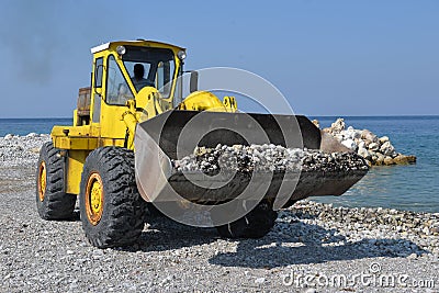 Piles of shingle dumped on the beach shore replenish and widen. Stock Photo