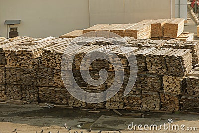 Piles of wooden planks at the seaport berth. Warehouse for sawing in stacks for loading in the open air. Material wooden wooden b Stock Photo