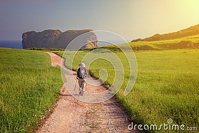 Pilgrim walking towards St. Martin church on the coast of LLanes to beach of the Camaras, Asturias, Spain Stock Photo