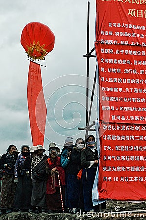 pilgrims are waiting next to a large chinese sign during a governmental announcement Editorial Stock Photo