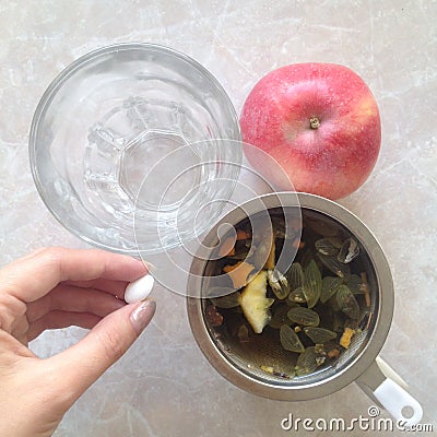 Pill in hand, herbal tea , water and red apple. Health care concept Stock Photo