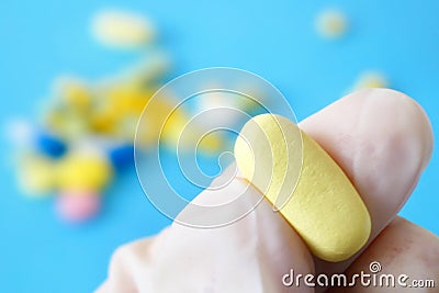 Pill takes in hand in gloves closeup, expired fake pills concept Stock Photo