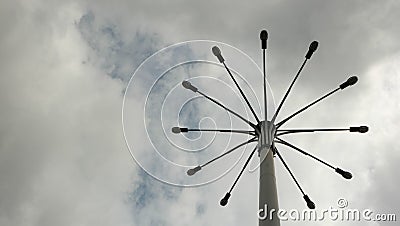 A pillar with a few lanterns against a cloudy sky. Stock Photo