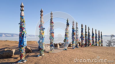 Pillars with colored ribbons on them in the place of power on lake Baikal - Cape Burhan near the village of Khuzhir. Lake Baikal Stock Photo