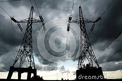 Pillars of line power electricity on gray storm clouds Stock Photo