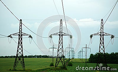 Pillars of line power electricity on green field Stock Photo