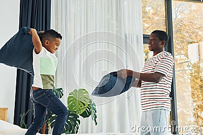 Pillow fight. African american father with his young son at home Stock Photo