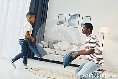 Pillow fight. African american father with his young son at home Stock Photo