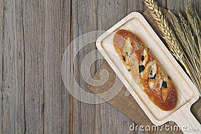 Pillow raisin bread and wheat ears and sack on wooden background,top view Stock Photo