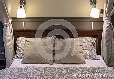 Pillows on a bed in a classic-style bedroom. Interior of a classic bedroom in beige tones Stock Photo