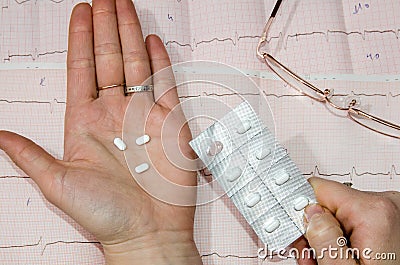 Pills above the cardiogram Stock Photo