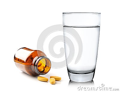Pills from bottle and Glass of water on white backgroun Stock Photo