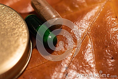 Pills and a bottlecap on a brown leaf Stock Photo