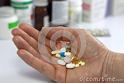 Pills in hand against medicines in pharmacy Stock Photo