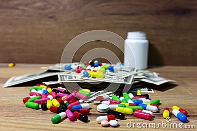 Pills in on a heap of American dollars. Economy concept of spending money on medicines and pills. Medical pill for maintaining and Stock Photo