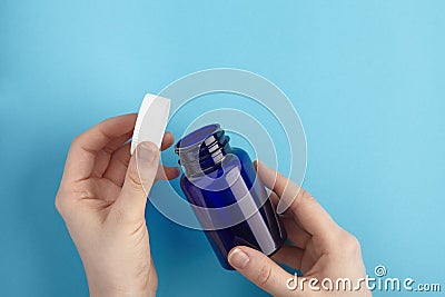 Pills package opened in a hands. Close up pill bottle on blue background. Medicine, medical insurance or pharmacy concept close up Stock Photo