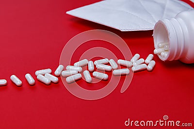 Pills and protective mask on a red background Stock Photo