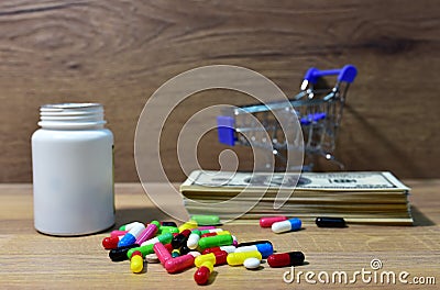 Pills in a shopping basket on a heap of American dollars. Economy concept of spending money on medicines and pills. Medical pill Stock Photo