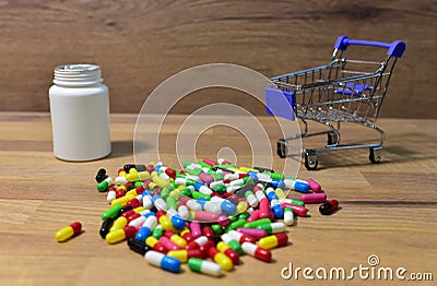 Pills at a shopping basket on wood backgrond. Economy concept of spending money on medicines and pills. Medical pill for Stock Photo