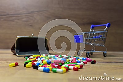 Pills with wallet at a shopping basket on wood backgrond. Economy concept of spending money on medicines and pills. Medical pill Stock Photo