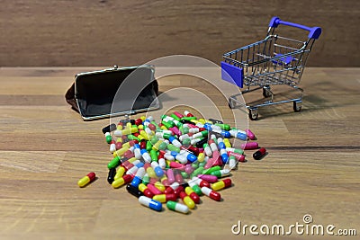 Pills with wallet at a shopping basket on wood backgrond. Economy concept of spending money on medicines and pills. Medical pill Stock Photo