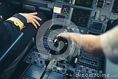 Pilot`s hand accelerating on the throttle in a commercial airliner airplane flight cockpit Stock Photo