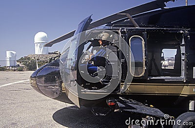 A pilot sitting in the cockpit of the Night Hawk helicopter used by the U.S. Customs Department at a Kitt Peak, Arizona, heliport Editorial Stock Photo