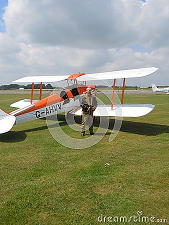 Pilot standing by historic biplane aircraft Editorial Stock Photo