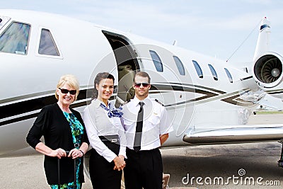 Pilot and stewardess with passenger by plane Stock Photo