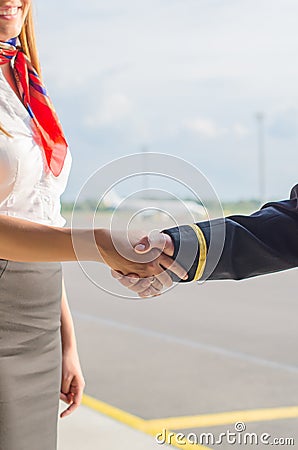 Pilot and stewardess shaking hands. Stock Photo