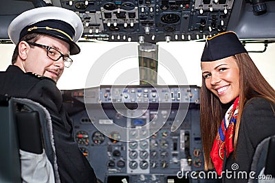 Pilot and stewardess sitting in an airplane cabin Stock Photo