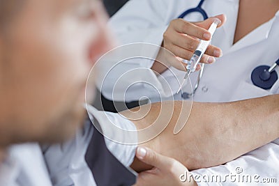 Pin in arm syringe pumping blood for test in hospital Stock Photo