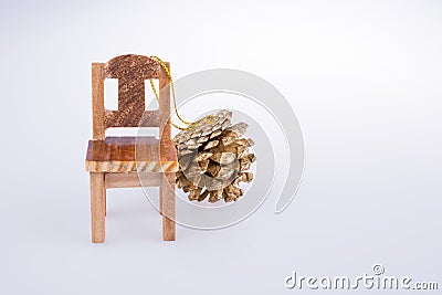 Pine cone bye the side of a little model chair Stock Photo