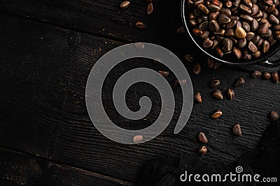 Pine wild organic nut, on black wooden table background, top view flat lay, with copy space for text Stock Photo