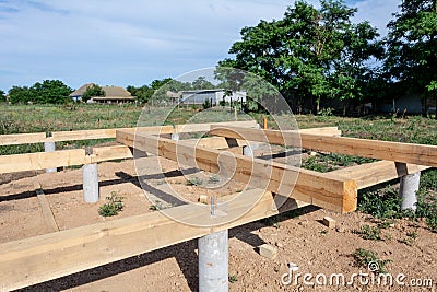 Pine wooden frame house foundation on concrete piles, construction site Stock Photo