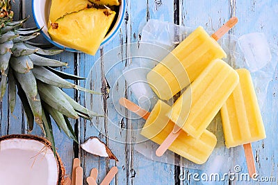 Pineapple coconut popsicles, top view scene over blue wood Stock Photo