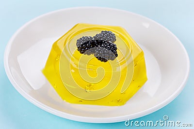 Pineapple jelly pudding decorated blackberries on a white plate Stock Photo