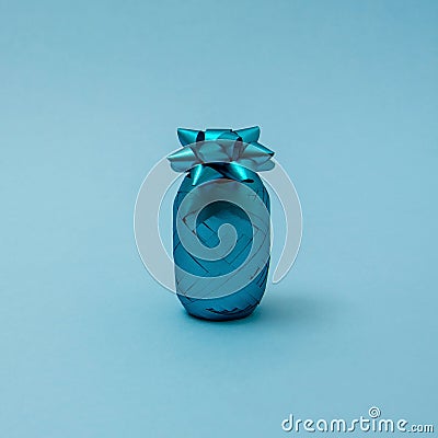 Pineapple made of turquoise ribbon for gift wrapping for Christmas, New year, birthday or anniversary on blue background. Minimal Stock Photo