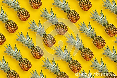pineapple pattern. many pineapples on bright yellow paper background, trendy flat lay. summer concept Stock Photo