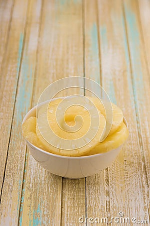 Pineapple rings in a white bowl. Canned ananas slices, copy space Stock Photo