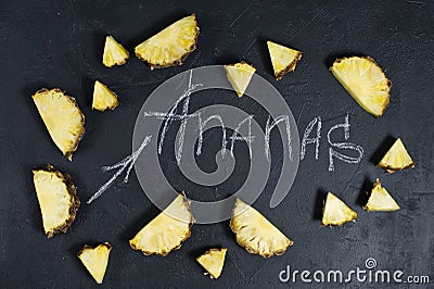 Pineapple slices on black background with space for text and chalk inscription. Stock Photo