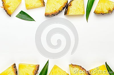 Pineapple slices with green leaves of pineapple on a white wooden background frame. Tropical juicy exotic healthy fruit Stock Photo